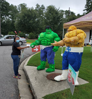 PEP Board Member, Rysheeka Bush, hands out information about early literacy  to the Hulk at the Fit 4 School event.