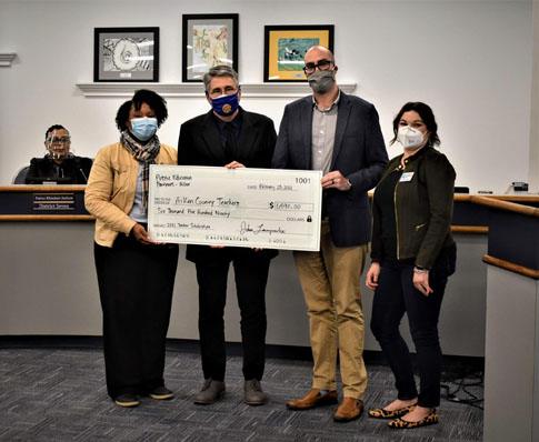 PEP board members Rysheeka Bush, John Lamprecht, and Rosalyn Greene present Aiken County Public School District superintendent King Laurence with a check to cover 13 classroom teacher grants for Aiken County educators.